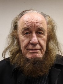 twarz starszego mężczyzny z wysokim czołem i długimi brązowymi włosami i brodą