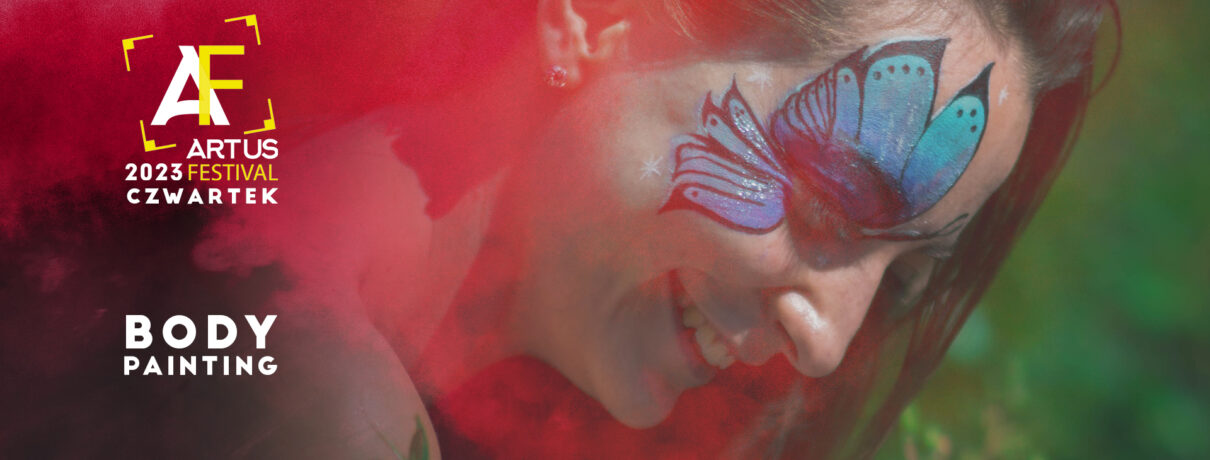 kobieta z namalowanym niebieskim motylem wącha kwiaty